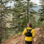 a lady wearing a yellow jacket hiking